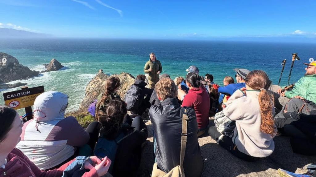 Group gathered on coastal cliffs overlooking the ocean